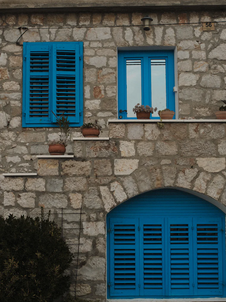 Mavi panjurlu taş konak cephesi